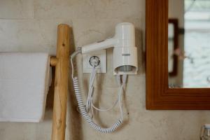 a white hair dryer hanging on a wall at Prabawa Ubud Villa in Ubud