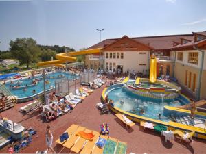 ザラカロシュにあるRelax Apartment Houseのリゾートの大きなプールで人々が椅子に座っている