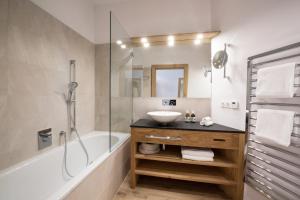 a bathroom with a sink and a tub and a shower at Hotel Stiegl-Gut Wildshut in Wildshut +59 photos