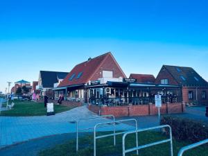 a group of buildings with tables and chairs at Katrin in Norddeich