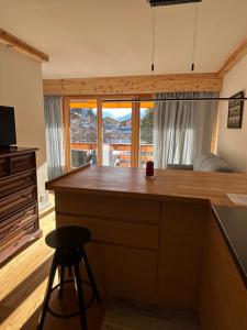 a kitchen with a bar with a view at Central flat in Villars sur Ollon, Amethyste, for 4, with two double beds, balcony and 75m to ski-train in Villars-sur-Ollon +21 photos