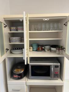 a kitchen with a microwave and bowls and plates at Mori no Kabe Tokyo #KT1 in Takahate