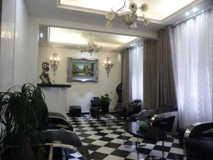 uma sala de espera com cadeiras e um piso xadrez em Camelia Prestige - Place de la Nation em Paris