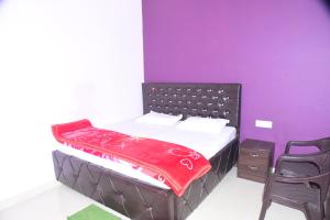 a bedroom with a bed with a red blanket on it at Hotel Naimisharanya Rameshwaram Dham in Naimishāranya