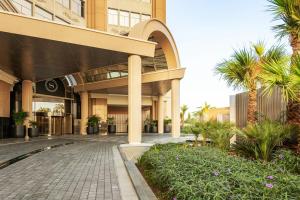 a building with palm trees in front of it at Sheraton Mall of the Emirates Hotel, Dubai in Dubai