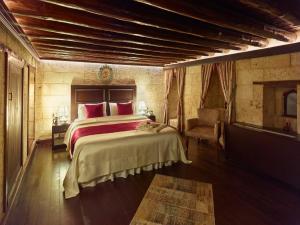 a bedroom with a large bed and a chair at Bey Konağı Butik Otel in Şahinbey