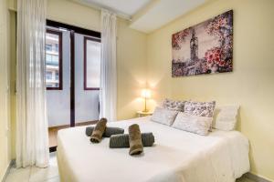 1 dormitorio con 1 cama blanca grande y zapatillas. en Lovely Calpe, en Calpe