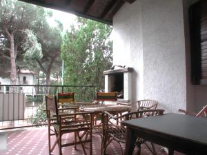 a patio with tables and chairs on a balcony at Villetta Marfisa in Lido di Spina