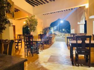 a restaurant with tables and chairs in a room at Stopover Guest House and Restaurant in Lamu