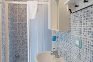 a blue tiled bathroom with a sink and a shower at Azzurromare in San Vito Chietino