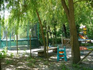 a park with a playground with a tree and a bench at La Valière in Chorges