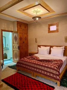 a bedroom with a bed and a chandelier at Riad Rose Mati in Marrakech