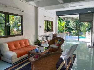 een woonkamer met een bank en een glazen tafel bij Mountain View Hostel - Krabi Airport near Wat ThamSuea in Krabi town