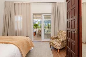 a bedroom with a bed and a chair and a door at Island lifestyle on the water in Knysna