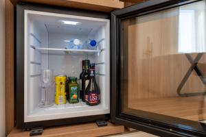 an open refrigerator with drinks and a wine glass at Puro By Unico Relais in Naples