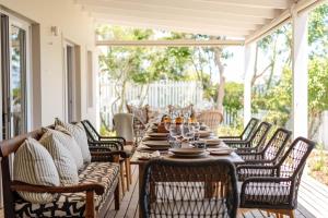 a table on a screened porch with chairs and a tableablish at Island lifestyle on the water in Knysna