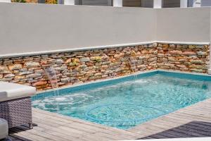 a swimming pool with a stone wall and waterfalls at Island lifestyle on the water in Knysna