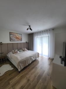 a white bedroom with a bed and a window at Willa Sielski Zakątek in Raba Wyżna
