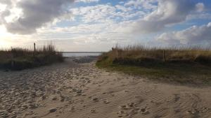 una spiaggia con impronte nella sabbia e nell'oceano di Residenz Trafalgar - Ferien-Apartments a Cuxhaven