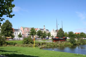 Una barca seduta in un fiume in una città di Residenz Trafalgar - Ferien-Apartments a Cuxhaven
