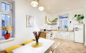 a kitchen with a white table and a white refrigerator at Bonton Apartments in Kežmarok +18 photos