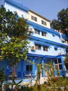 un edificio blu con alberi di fronte di Tara Guest House a Bodh Gaya