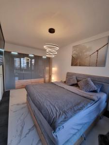 a bedroom with a large bed and a chandelier at Hafenperle in Bad Zwischenahn