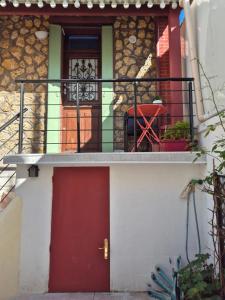 a house with a red door and a balcony at House Paris 13ème in Ivry-sur-Seine