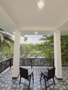 a porch with two chairs and a view of the ocean at The Waterside Haven in Tangalle