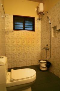a bathroom with a toilet and a window at Sarovaram -Beautiful Riverfront Villa Kochi in Ernakulam