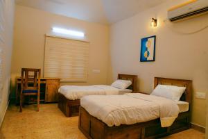 a room with two beds and a chair in it at Sarovaram -Beautiful Riverfront Villa Kochi in Ernakulam
