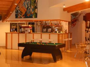 a pool table in a room with a bar at Hôtel Eco Logis in Séméac