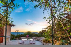 a patio with a table and chairs and the sunset at La Belle Villa - Family Retreat Magnificent View in Akrotiri