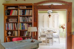 a dining room with a table and a book shelf filled with books at La Belle Villa - Family Retreat Magnificent View in Akrotiri