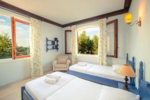 two beds in a room with two windows at La Belle Villa - Family Retreat Magnificent View in Akrotiri