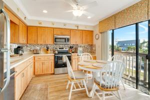 a kitchen with wooden cabinets and a table and chairs at Coastal Lakehouse Condo on Siesta Key Public Beach in Sarasota