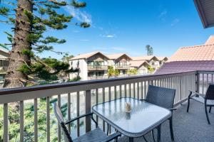 a patio with a table and chairs on a balcony at Coastal Lakehouse Condo on Siesta Key Public Beach in Sarasota
