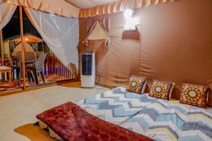 una camera da letto con un letto con cuscini di Publiq Darbar Tent House a Pune