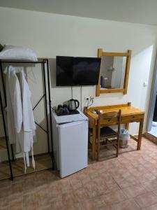 a room with a desk and a television and a table at Hotel Almira in Agia Triada +37 photos