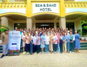 a group of people posing for a picture in front of a hotel at Sea and Sand Hotel in Hoi An +30 photos