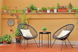 two chairs and a table with potted plants on a wall at San Paolo's apartment in Rome