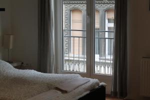 a bedroom with a bed and a large window at Erkel Apartment in Budapest