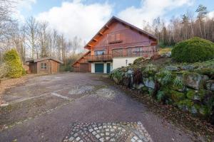 a large house with a stone wall next to a driveway at Chalet La Rayée - Vue lac et montagne 14p in Gérardmer