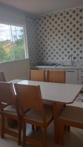 a kitchen with a table and chairs and a window at Casa Vista da Pedra in Domingos Martins +3 photos