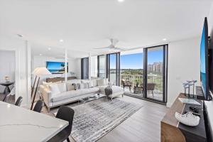 a living room with a white couch and a tv at Beachfront condo with views of beach and spacious pool in Marco Island