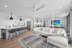 a living room with a white couch and a kitchen at Beachfront condo with views of beach and spacious pool in Marco Island