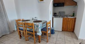 a kitchen with a table and chairs and a kitchen with a counter at Ioannidis - Sigri- Apartments in Sígrion
