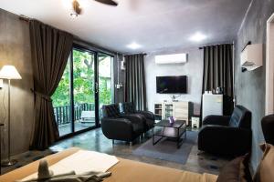 sala de estar con sillones y TV en Judy Park & Resort Buriram, en Ban Nong Hua Wua