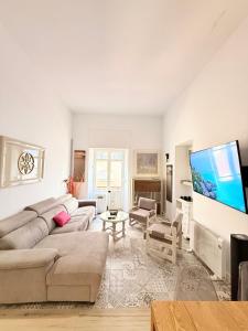 a living room with a couch and a flat screen tv at Riad 1 2C in Melilla +3 photos