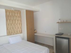 a small bedroom with a bed and a desk at Avra Studios in Myrties